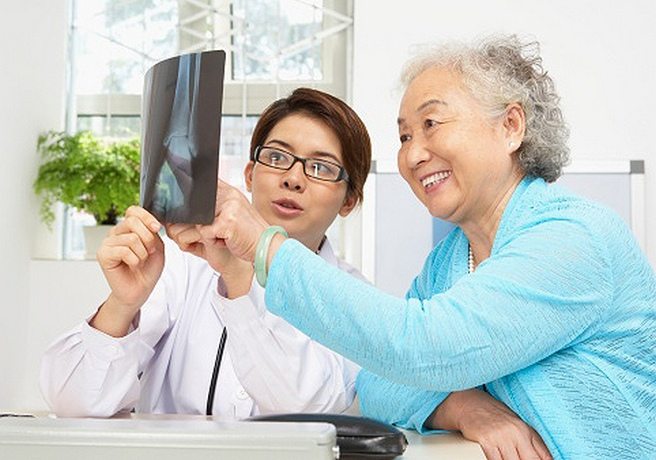 Врач показывает пациенту рентгеновский снимок Врач с пациентом